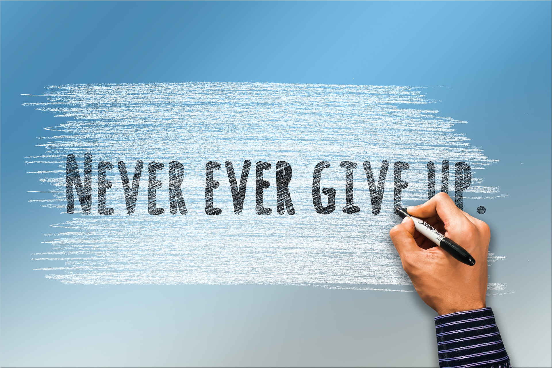 a hand has drawn on a blue to white gradient background, the words, 'Never Ever Give up' in Sharpie.